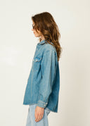 Woman wearing a denim jacket against a plain background